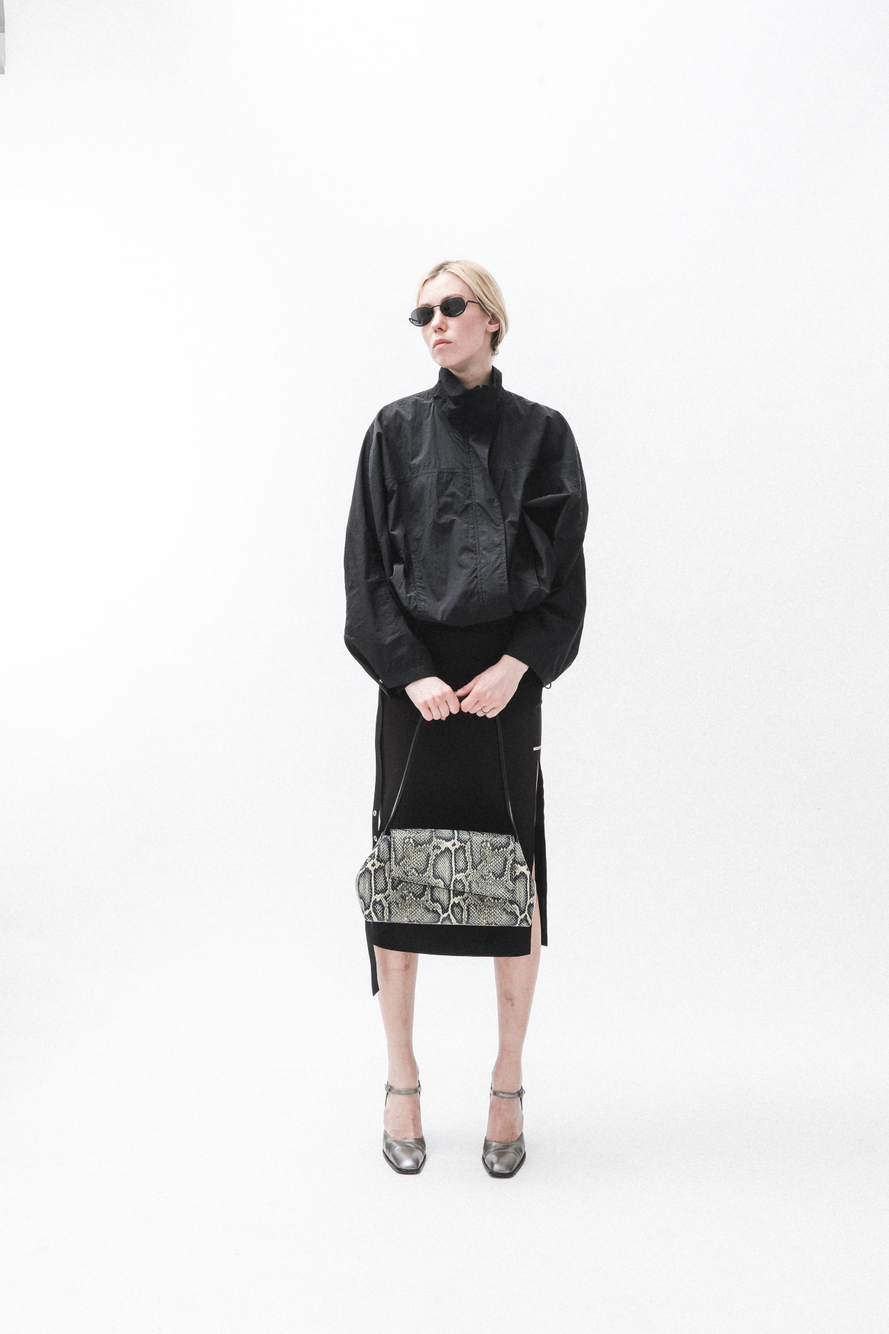 Model holding a large snake-print bag